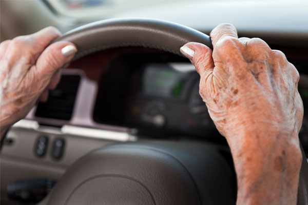 old woman's hands on steering wheel