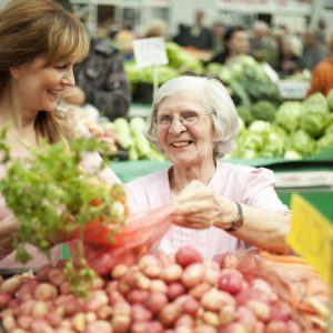 The elderly woman at the market place with daughter