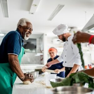 Senior man making pasta in a cooking class