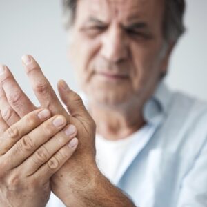 older adult man with pain in hands from arthritis