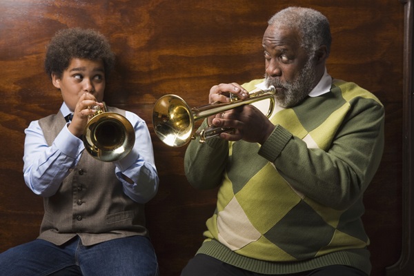 grandfather and grandson playing trumpets together