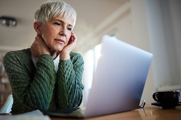 Senior woman reading an e-mail on a computer at home.