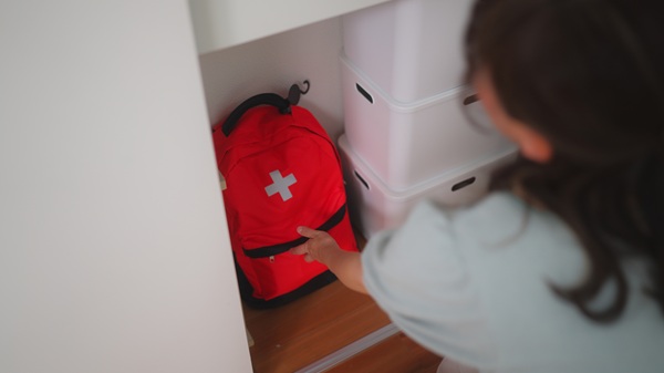 A woman is preparing an emergency bag in the living room at home.
